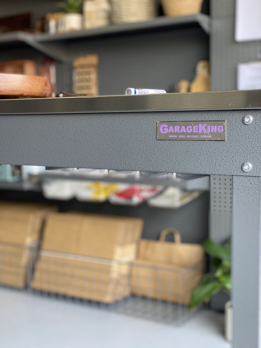 A metal garage workbench with packaging products in the background