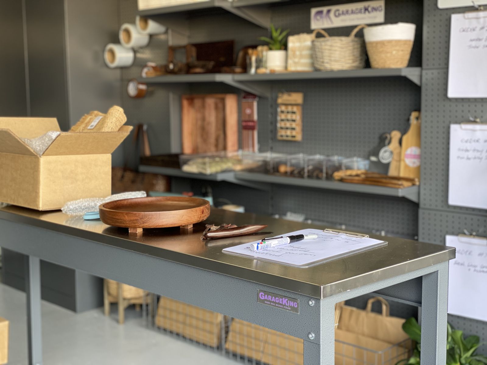 A stainless steel workbench with garage stooging shelves set up as a homewares business