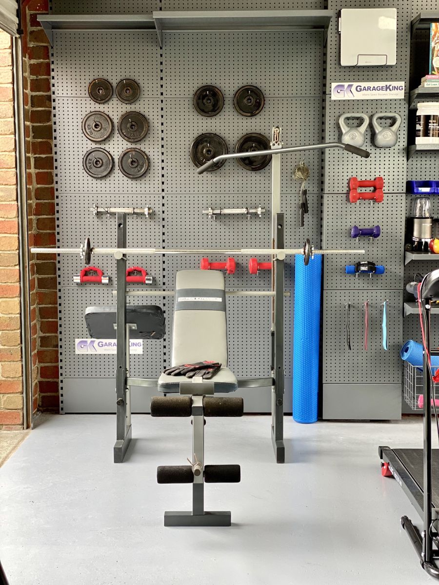 A home garage gym set up in a melbourne home gym garage with weights, weight bench, and workout gear