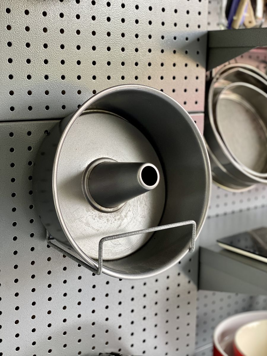 Garage storage perforated pegboard storage with garden hose holder and cake tin