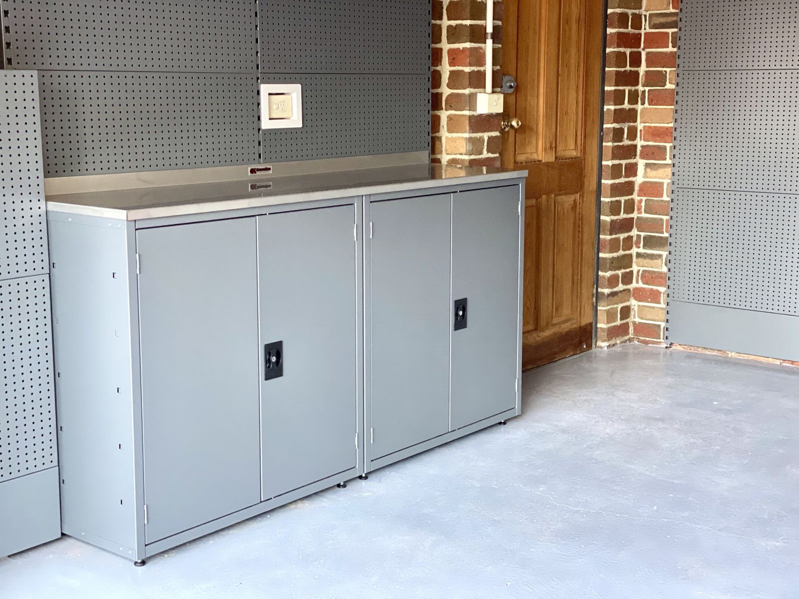 Garage storage solution with work bench, cabinets and perforated wall