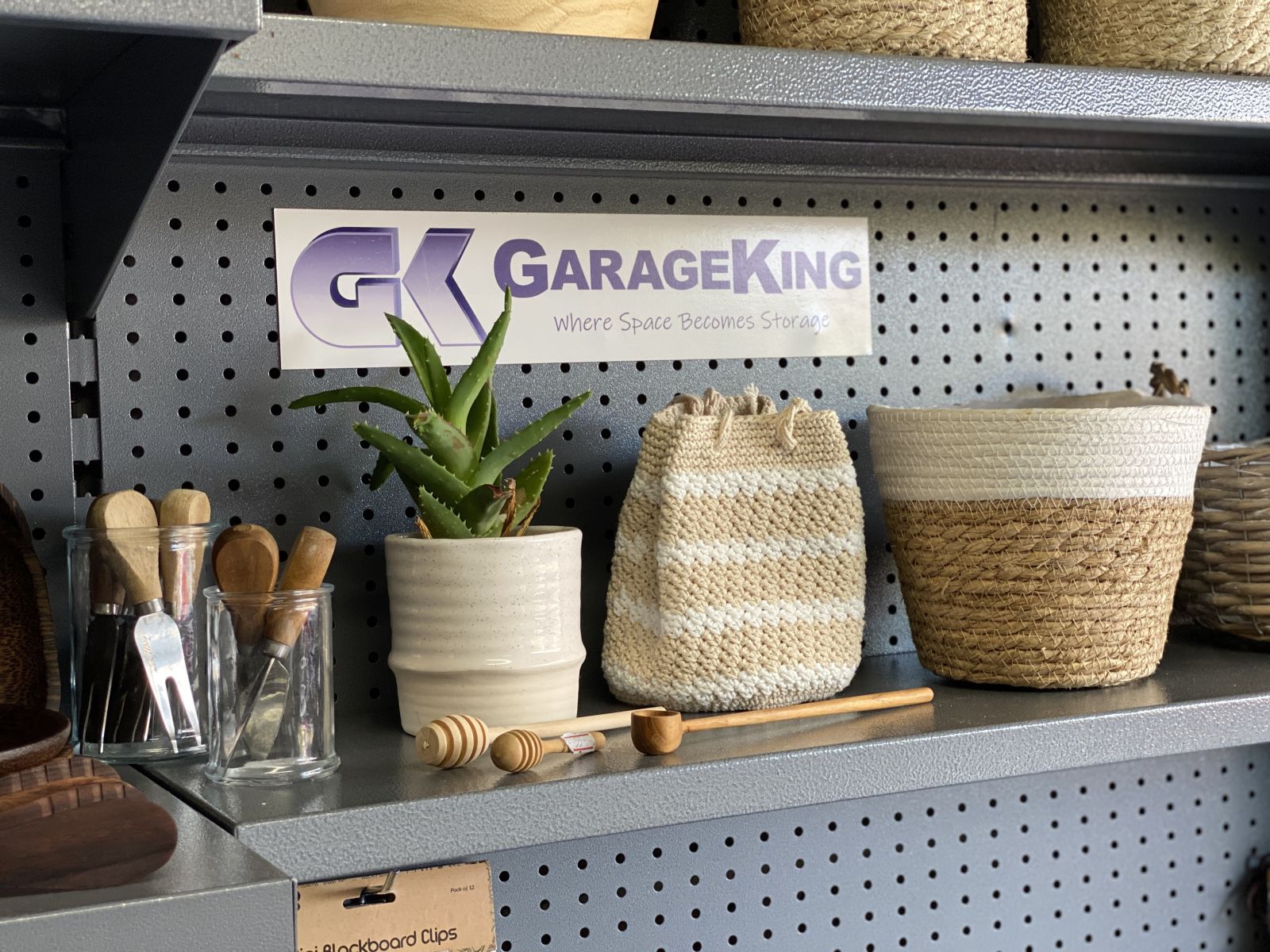 A grey metal garage storage shelf with homewares displayed